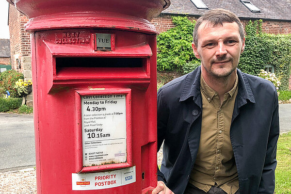 Councillor Alec Sandiford standing next to a post box